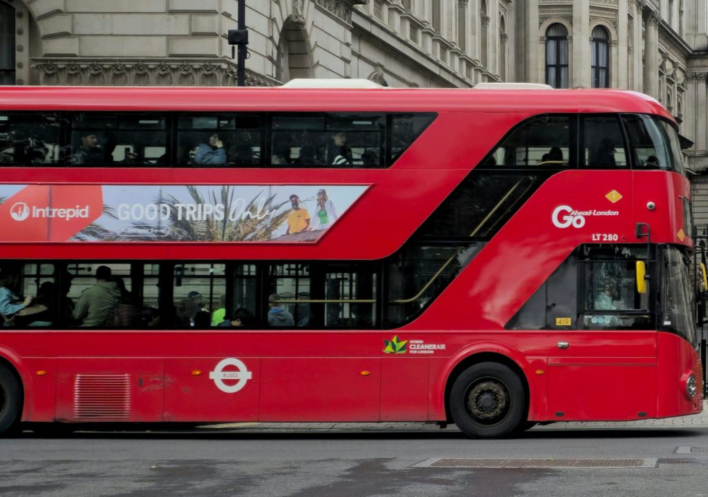 Red London double-decker bus with side advertising