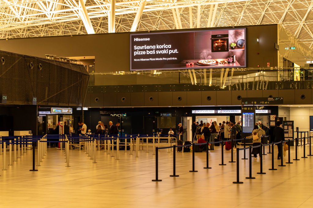 Large digital advertising screen inside an airport terminal