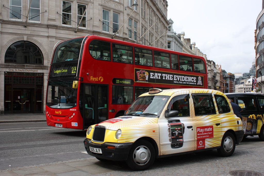 Red London bus and black cab near St Paul's Cathedral